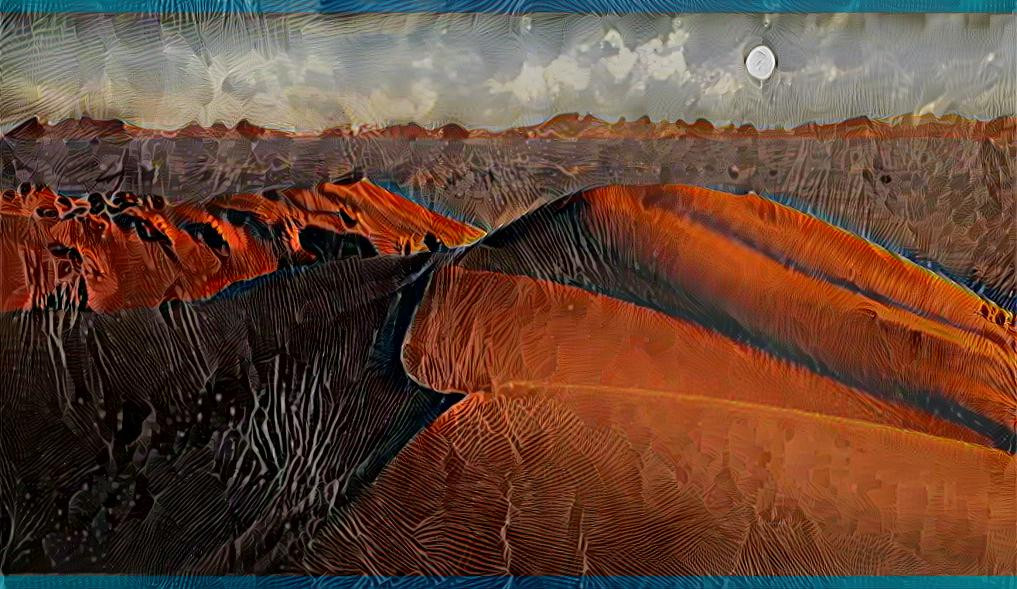 The moon rises slowly over the Namib desert dunes